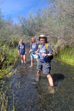 three young women wading in creek during Beaver Scavenger Hunt, photo by Robert Owens